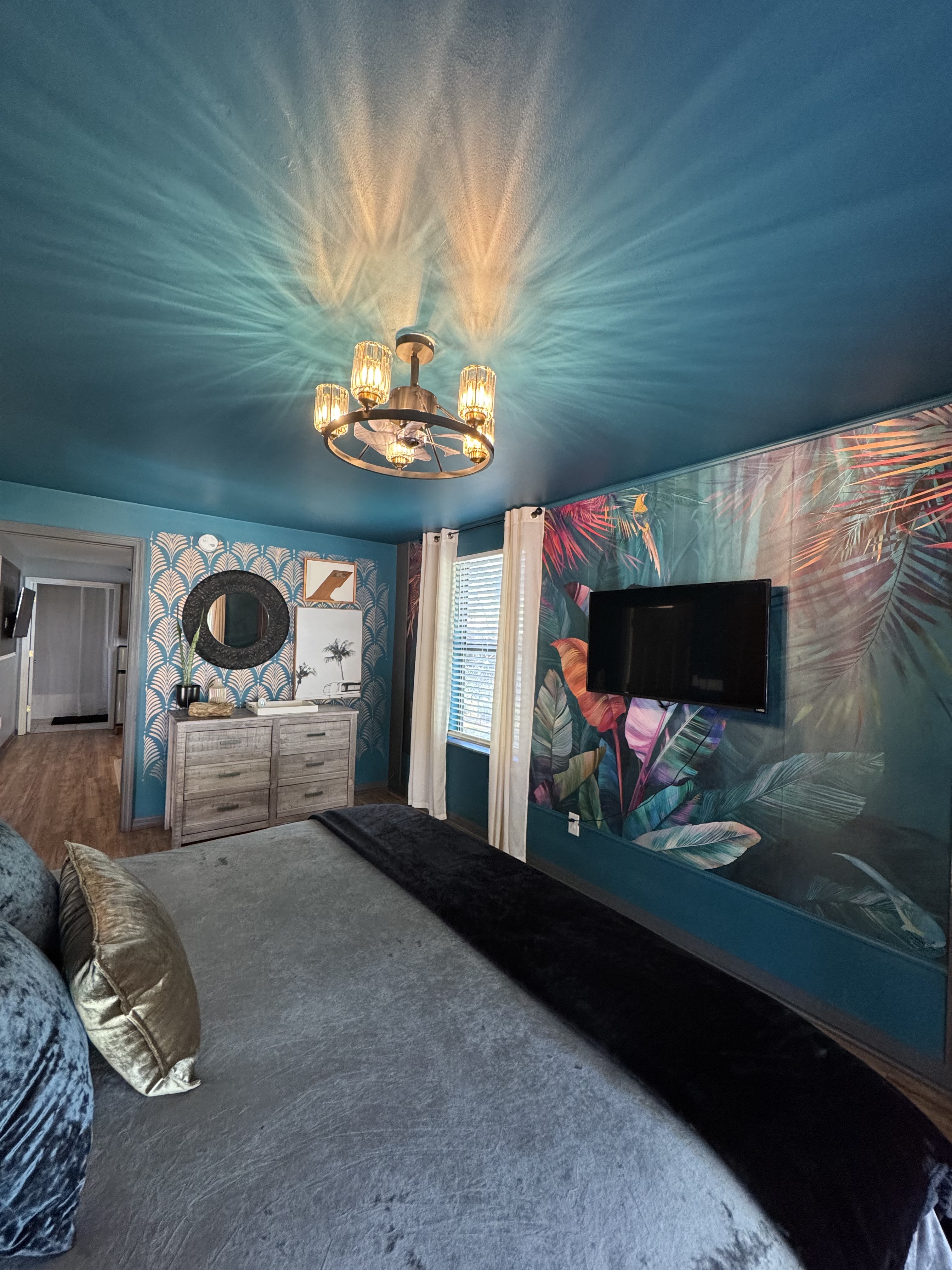 Feher's Lair — tropical mural bedroom, teal ceiling, chandelier