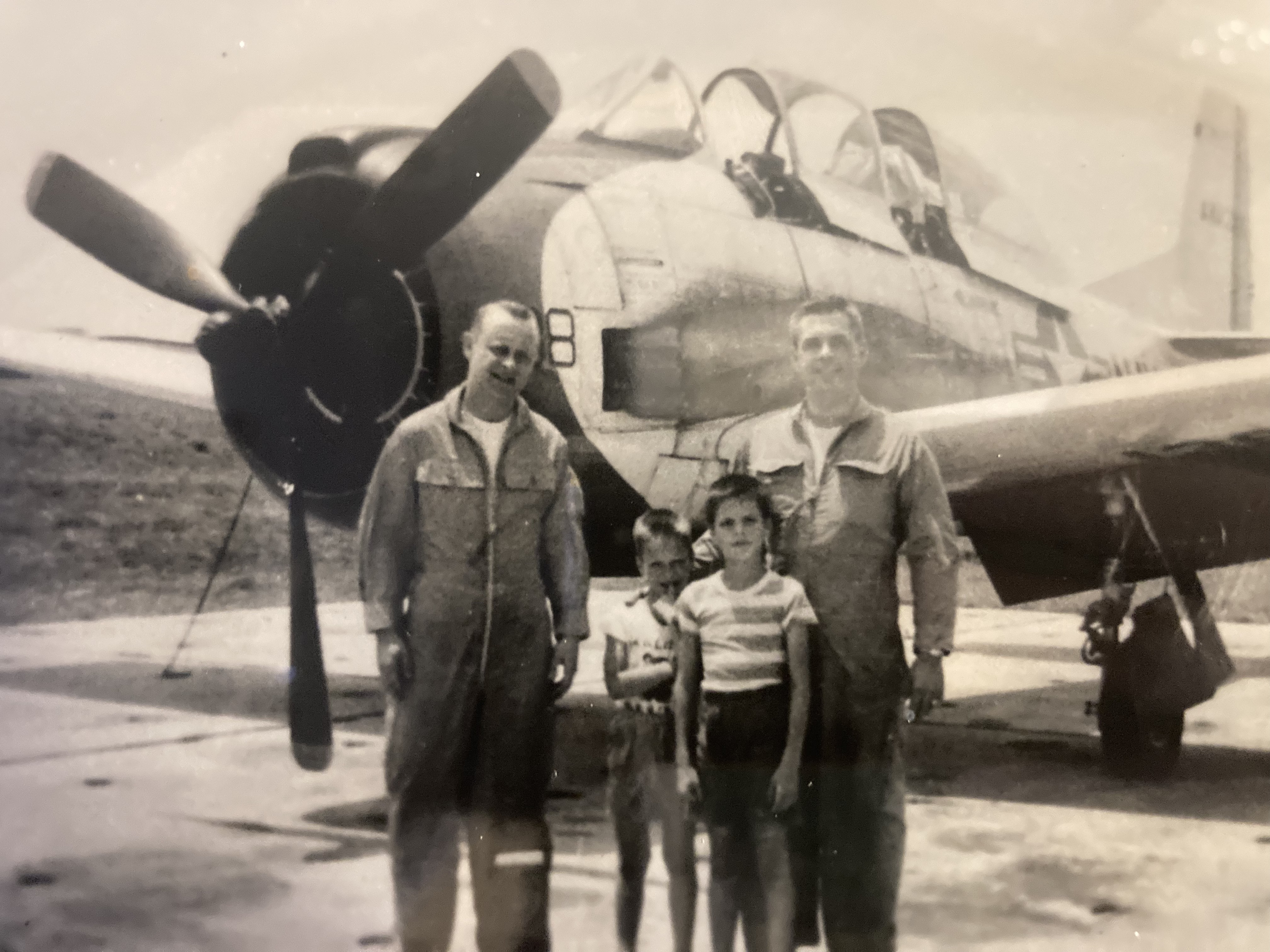 Arthur J. Feher with fellow aviator and children in front of a propeller aircraft